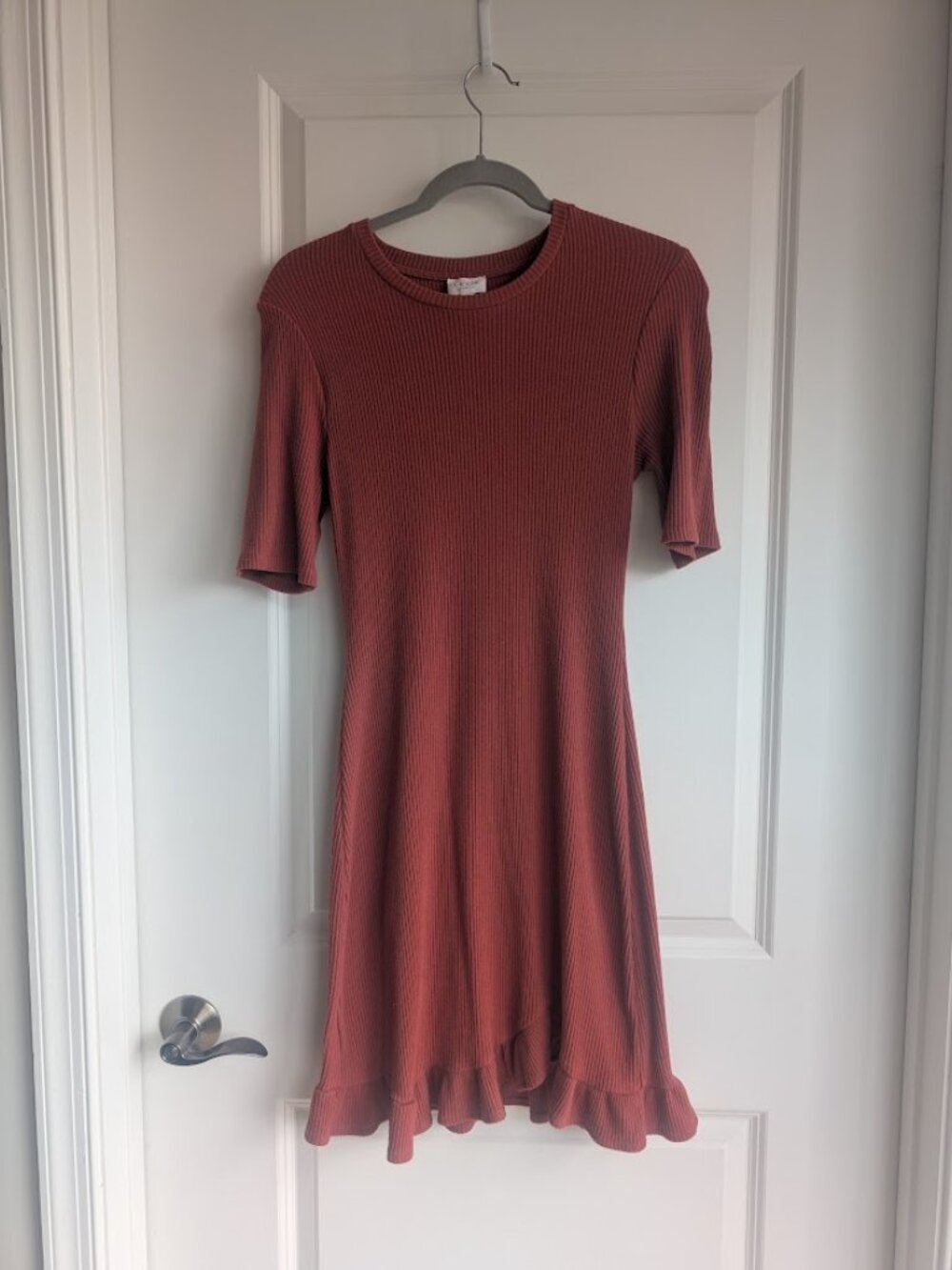 Flattering rust-orange stretchy-knit dress with ruffle hemline. By Le Lis.